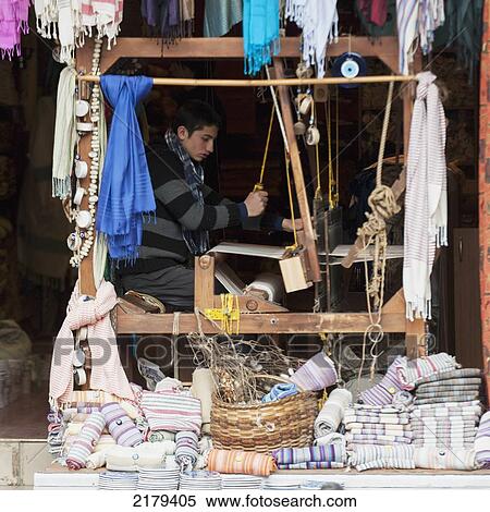 A Young Man Works A Loom In A Shop With Displays Of Fabric Out Front; Istanbul Turkey View Large Photo Image Stock Photography - A Young Man Works A Loom In A Shop With Displays Of Fabric Out Front; Istanbul Turkey. Fotosearch