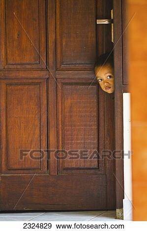 A Young Shy Indonesian Boy Pokes His Head Out The Door, Bali, Indonesia View Large Photo Image Stock Photo - A Young Shy Indonesian Boy Pokes His Head Out The Door, Bali, Indonesia. Fotosearch