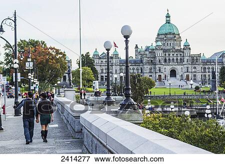 A young tourist couple walking the waterfront towards the Parliament Buildings; Victoria, Vancouver Island, British Columbia View Large Photo Image Stock Photo - A young tourist couple walking the waterfront towards the Parliament Buildings; Victoria, Vancouver Island, British Columbia. Fotosearch