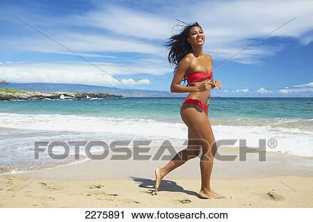 A young woman in a red bikini running on the beach of an hawaiian island; Maui, Hawaii, United States of America View Large Photo Image Stock Image - A young woman in a red bikini running on the beach of an hawaiian island; Maui, Hawaii, United States of America. Fotosearch