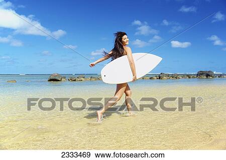 A young woman in a strapless bikini with a surfboard; Kauai, Hawaii, United States of America View Large Photo Image Stock Photo - A young woman in a strapless bikini with a surfboard; Kauai, Hawaii, United States of America. Fotosearch