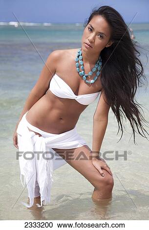 A young woman in a white bikini stands in the shallow ocean water; Oahu, Hawaii, United States of America View Large Photo Image Stock Image - A young woman in a white bikini stands in the shallow ocean water; Oahu, Hawaii, United States of America. Fotosearch