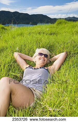 A Young Woman Lays On The Grass With A View Of The Coastline; Urupukapuka Island, New Zealand View Large Photo Image Stock Photograph - A Young Woman Lays On The Grass With A View Of The Coastline; Urupukapuka Island, New Zealand. Fotosearch