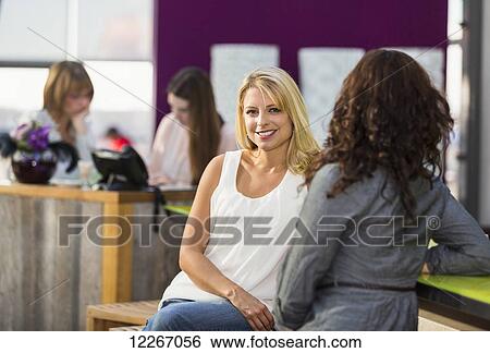 A young woman looking at the camera in a cafe; St. Albert, Alberta, Canada View Large Photo Image Stock Photograph - A young woman looking at the camera in a cafe; St. Albert, Alberta, Canada. Fotosearch