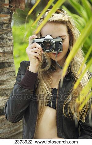 A young woman looking through the camera at the camera; Kauai, Hawaii, United States of America View Large Photo Image Stock Image - A young woman looking through the camera at the camera; Kauai, Hawaii, United States of America. Fotosearch
