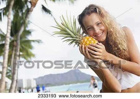 A young woman poses with a fresh pineapple and Diamond Head in the background; Oahu, Hawaii, United States of America View Large Photo Image Stock Image - A young woman poses with a fresh pineapple and Diamond Head in the background; Oahu, Hawaii, United States of America. Fotosearch