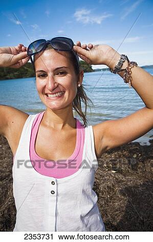 A Young Woman Poses With Sunglasses Along The Coast Of Urupukapuka Island; New Zealand View Large Photo Image Stock Image - A Young Woman Poses With Sunglasses Along The Coast Of Urupukapuka Island; New Zealand. Fotosearch
