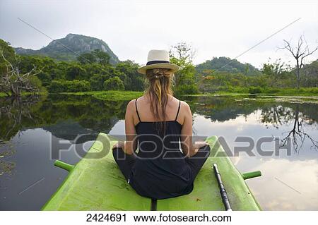 A young woman sits on a green raft in the tranquil water; Ulpotha, Embogama, Sri Lanka View Large Photo Image Stock Image - A young woman sits on a green raft in the tranquil water; Ulpotha, Embogama, Sri Lanka. Fotosearch