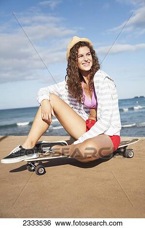 A young woman sits on a skateboard on a beach; Honolulu, Oahu, Hawaii, United States of America View Large Photo Image Stock Photograph - A young woman sits on a skateboard on a beach; Honolulu, Oahu, Hawaii, United States of America. Fotosearch