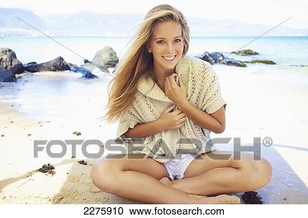A young woman sits on the beach of an hawaiian island; Maui, Hawaii, United States of America View Large Photo Image Stock Image - A young woman sits on the beach of an hawaiian island; Maui, Hawaii, United States of America. Fotosearch