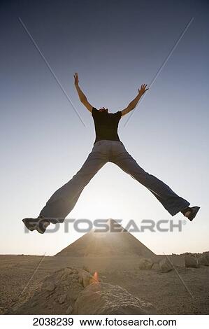 Stock Photo - A Young Woman Tourist Jumps In The Air At The Red Pyramid; Dashur Egypt. Fotosearch