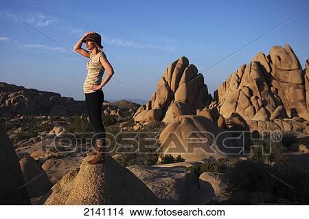 Picture - A young woman watches the sunset in Joshua Tree National Park; California, United States of America. Fotosearch