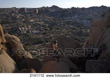A young woman watches the sunset in Joshua Tree National Park; California, United States of America View Large Photo Image Stock Image - A young woman watches the sunset in Joshua Tree National Park; California, United States of America. Fotosearch