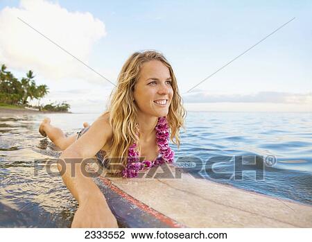 A Young Woman Wearing A Lei Rides A Surfboard Out In The Water; Maui, Hawaii, United States Of America View Large Photo Image Stock Image - A Young Woman Wearing A Lei Rides A Surfboard Out In The Water; Maui, Hawaii, United States Of America. Fotosearch