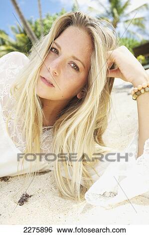Stock Photograph - A young woman with long blond hair posing on a beach; Maui, Hawaii, United States of America. Fotosearch