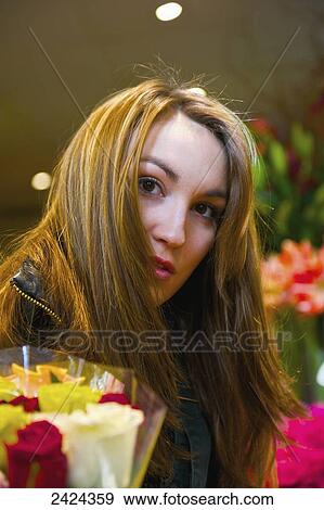 A young woman with long brunette hair shopping for flowers; Paris, France View Large Photo Image Stock Photo - A young woman with long brunette hair shopping for flowers; Paris, France. Fotosearch