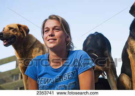 Stock Image - A Young Woman With Sheep Dogs At Blue Duck Lodge, In The Whanganui National Park; Whanganui, New Zealand. Fotosearch