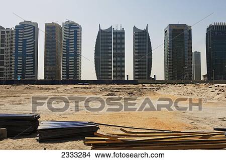 Abandoned Construction Site In Front Of Office And Residential High-Rise Buildings Along Sheikh Zayed Road; Dubai, United Arab Emirates View Large Photo Image Picture - Abandoned Construction Site In Front Of Office And Residential High-Rise Buildings Along Sheikh Zayed Road; Dubai, United Arab Emirates. Fotosearch