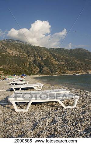 Abandoned Sun Loungers On A Pebbly Beach, The National Park, Oludeniz At The Turquoise Coast, Southern Turkey View Large Photo Image Stock Photography - Abandoned Sun Loungers On A Pebbly Beach, The National Park, Oludeniz At The Turquoise Coast, Southern Turkey. Fotosearch