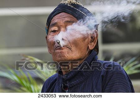 Abdi dalem (court retainer) wearing a distinctive Yogyakartan blangkon headdress, smoking a cigarette at the Kraton (Sultan's Palace), Yogyakarta, Java Island, Indonesia View Large Photo Image Stock Image - Abdi dalem (court retainer) wearing a distinctive Yogyakartan blangkon headdress, smoking a cigarette at the Kraton (Sultan's Palace), Yogyakarta, Java Island, Indonesia. Fotosearch