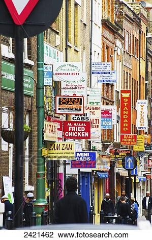 Stock Image - Abundance of signs mounted on the sides of buildings in Brick Lane; London, England. Fotosearch