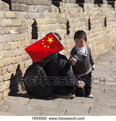 Stock Image - Adult And Child With Chinese Flag On The Great Wall Of China; Beijing, China. Fotosearch
