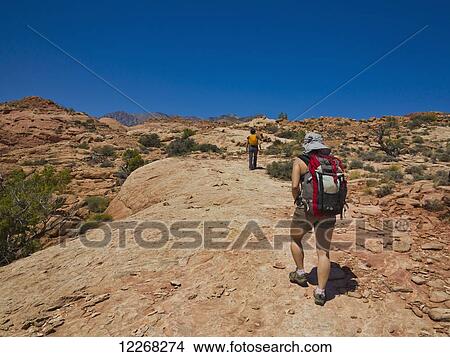 Adventurers exploring a desert slot canyon; Hanksville, Utah, United States of America View Large Photo Image Picture - Adventurers exploring a desert slot canyon; Hanksville, Utah, United States of America. Fotosearch