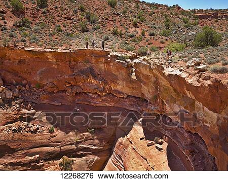 Adventurers exploring a desert slot canyon; Hanksville, Utah, United States of America View Large Photo Image Stock Photograph - Adventurers exploring a desert slot canyon; Hanksville, Utah, United States of America. Fotosearch