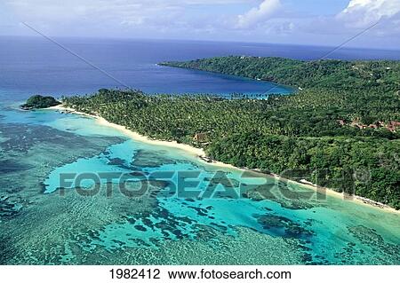 Stock Image - Aerial view of a beach-lined coast including the Wakaya Club; Wakaya, Fiji. Fotosearch