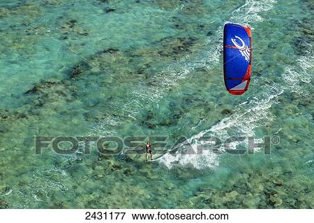 Stock Photo - Aerial view of a kiteboarder riding across the crystal clear blue waters; Anegada Island, British Virgin Islands. Fotosearch