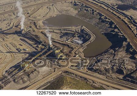 Aerial view of an oil sands refinery work site showing working equipment, pipelines, tailings and production industrial equipment, north of Fort McMurray; Alberta, Canada View Large Photo Image Stock Image - Aerial view of an oil sands refinery work site showing working equipment, pipelines, tailings and production industrial equipment, north of Fort McMurray; Alberta, Canada. Fotosearch