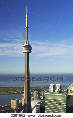 Stock Image - Aerial view of CN tower looking towards downtown Toronto, Island airport and Lake Ontario from First Canadian Place; Toronto, Ontario, Canada. Fotosearch