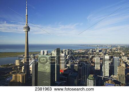 Stock Image - Aerial view of CN tower looking towards downtown Toronto, Island airport and Lake Ontario from First Canadian Place; Toronto, Ontario, Canada. Fotosearch