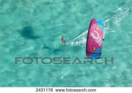 Stock Photo - Aerial view of professional kiteboarder Susi Mai kitesurfing across the crystal clear blue waters; Anegada Island, British Virgin Islands. Fotosearch