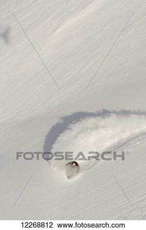 Stock Image - Aerial view of snowboarder on snowy slope; Haines, Alaska, United States of America. Fotosearch