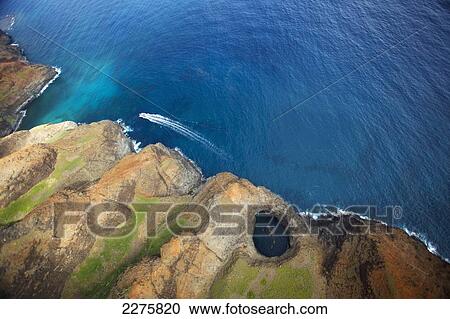 Aerial view of the rugged coastline and a boat in the pacific ocean along an hawaiian island; Na Pali coast of Kauai, Hawaii, United States of America View Large Photo Image Stock Image - Aerial view of the rugged coastline and a boat in the pacific ocean along an hawaiian island; Na Pali coast of Kauai, Hawaii, United States of America. Fotosearch