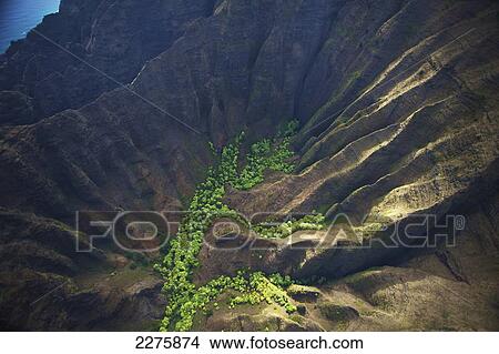 Picture - Aerial view of the rugged landscape along the coast of a hawaiian island, Na Pali coast; Kauai, Hawaii, United States of America. Fotosearch