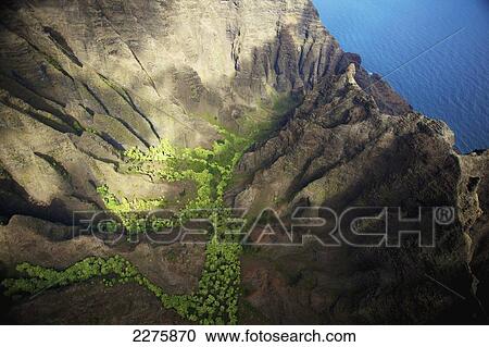 Stock Image - Aerial view of the rugged landscape along the coast of a hawaiian island, Na Pali coast; Kauai, Hawaii, United States of America. Fotosearch