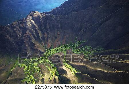 Aerial view of the rugged landscape along the coast of a hawaiian island, Na Pali coast; Kauai, Hawaii, United States of America View Large Photo Image Stock Photography - Aerial view of the rugged landscape along the coast of a hawaiian island, Na Pali coast; Kauai, Hawaii, United States of America. Fotosearch