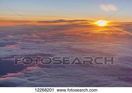 Aerial view of the sun peeking through the couds at sunrise, Arctic Alaska, summer View Large Photo Image Stock Image - Aerial view of the sun peeking through the couds at sunrise, Arctic Alaska, summer. Fotosearch