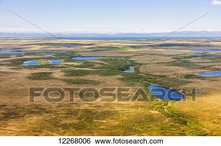 Stock Photograph - Aerial view of tundra and lakes, Baldwin Peninsula, Baird Mountains visible in the background, Arctic Alaska, summer. Fotosearch