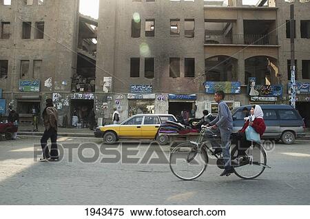 Stock Photography - Afghan Boy And Girl Ride A Bicycle Through A Kabul Street,, Afghanistan. Fotosearch