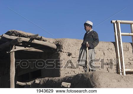 Stock Photo - Afghan Boy On The Roof Of A Mud House In Kharwalang, Vardak Province, Afghanistan. Fotosearch