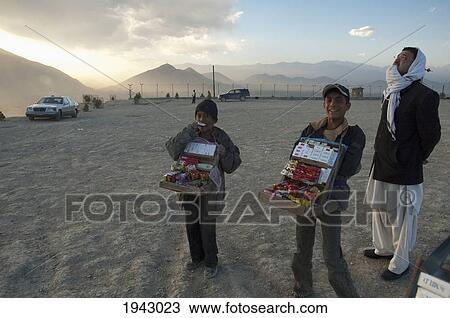 Stock Image - Afghan Boys Selling Cigarettes And Candy On The Tapa Maranjan Ridge In Kabul,, Afghanistan. Fotosearch