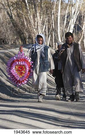 Stock Photography - Afghan Man And Boys Carrying A Wedding Ornament On The Road To Tajekha, Vardak Province, Afghanistan. Fotosearch