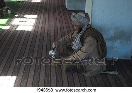 Afghan Man Pouring A Glass Of Tea In A Restaurant In Zarkharid, Vardak Province, Afghanistan View Large Photo Image Stock Photo - Afghan Man Pouring A Glass Of Tea In A Restaurant In Zarkharid, Vardak Province, Afghanistan. Fotosearch