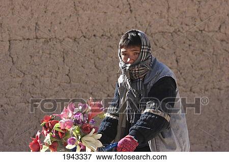 Stock Photo - Afghan Man Riding A Bicycle With Plastic Flowers Decorating The Handle Bars In Bamiyan, Bamian Province, Afghanistan. Fotosearch