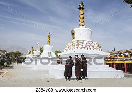 Stock Photo - Aged Tibetan pilgrims are happy to visit stupas (temples) at Wutun Si monastery; Tibet, China. Fotosearch