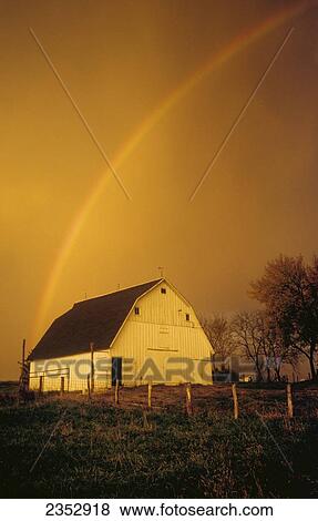 Agriculture - A rainbow arcs over a gambrel roof barn in dramatic stormy light / Northwest Missouri, USA. View Large Photo Image Stock Photo - Agriculture - A rainbow arcs over a gambrel roof barn in dramatic stormy light / Northwest Missouri, USA.. Fotosearch