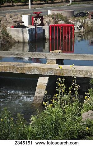 Agriculture - Agriculture - An gate in an irrigation canal allows the farmer to draw water from the canal to irrigate his crop. The water is held back by the canal drop in the foreground / near Dinuba, California, USA. View Large Photo Image Stock Image - Agriculture - Agriculture - An gate in an irrigation canal allows the farmer to draw water from the canal to irrigate his crop. The water is held back by the canal drop in the foreground / near Dinuba, California, USA.. Fotosearch